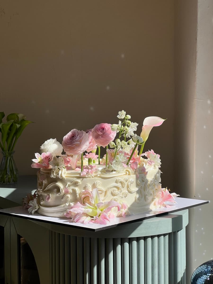 Pastel con relieve barroco y flores frescas